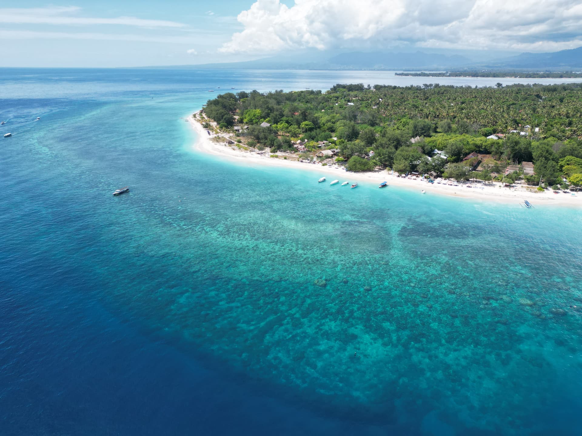 Eigen dronefoto van de groene kust en het rif rond Gili Meno