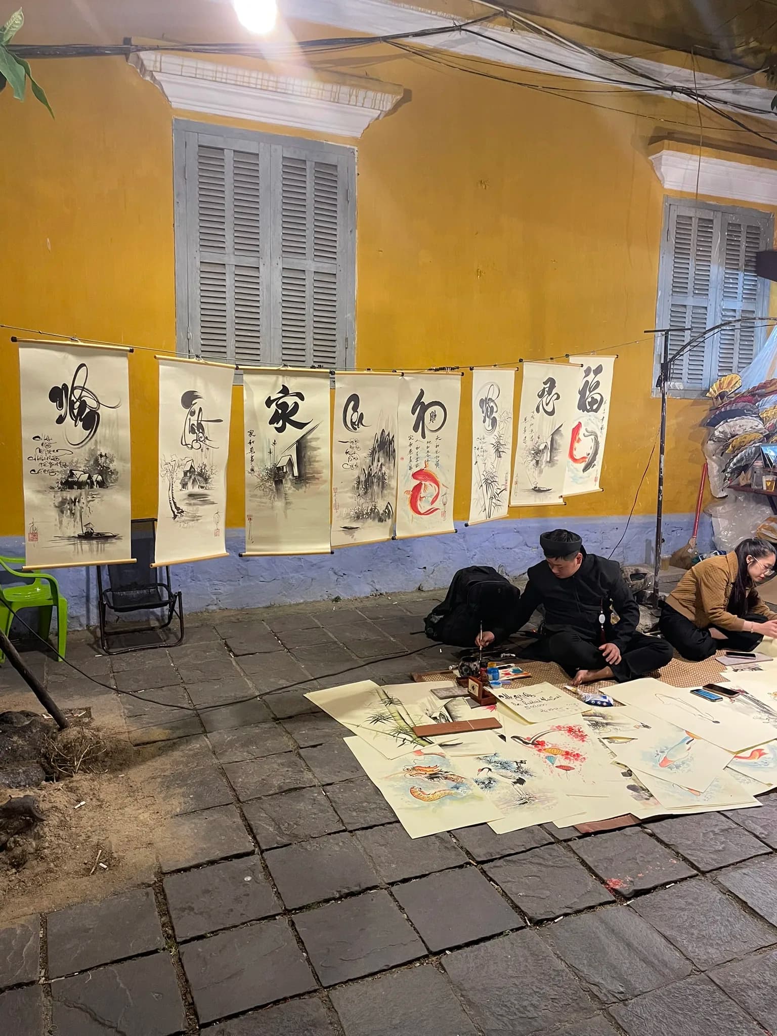 Kunstwerken en kalligrafie uitgestald in een straat van Hoi An