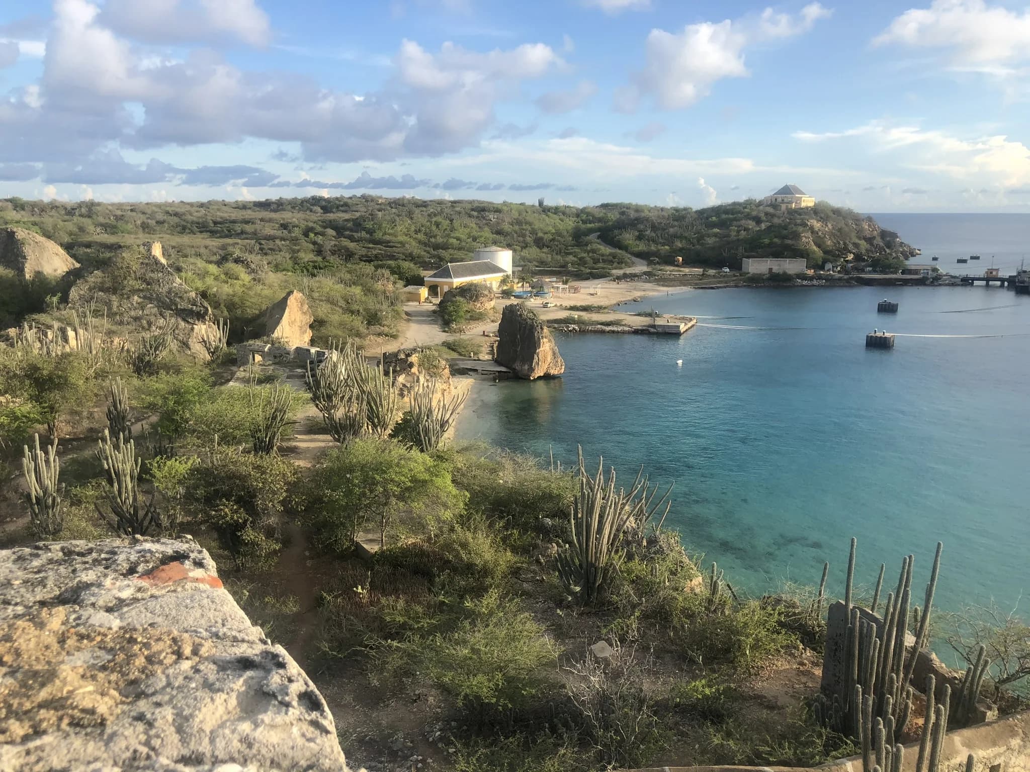 Rotsachtige kust en helder water bij Tugboat Beach aan Caracasbaai