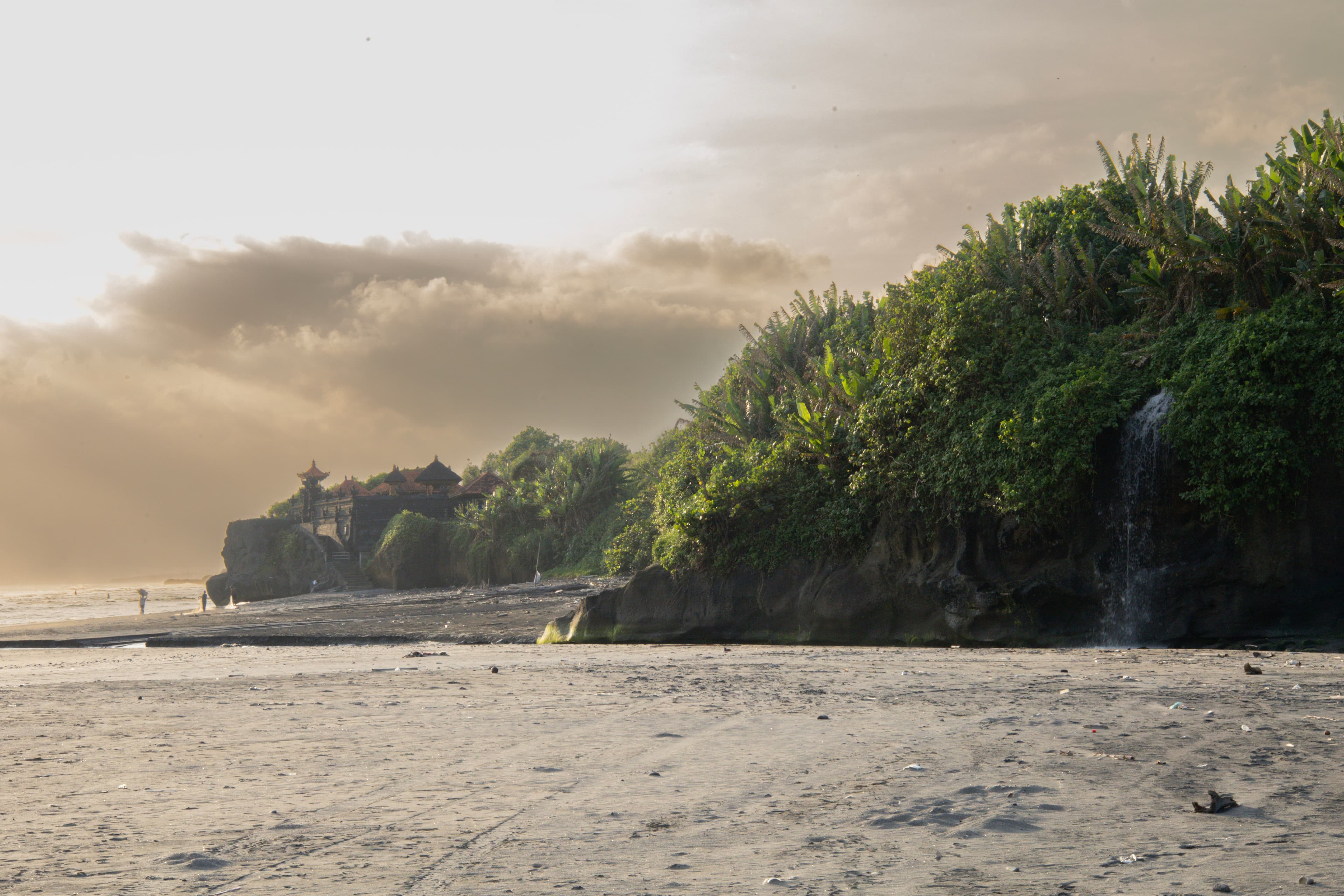 Het zwarte zandstrand van Yeh Gangga met tempel aan de kust