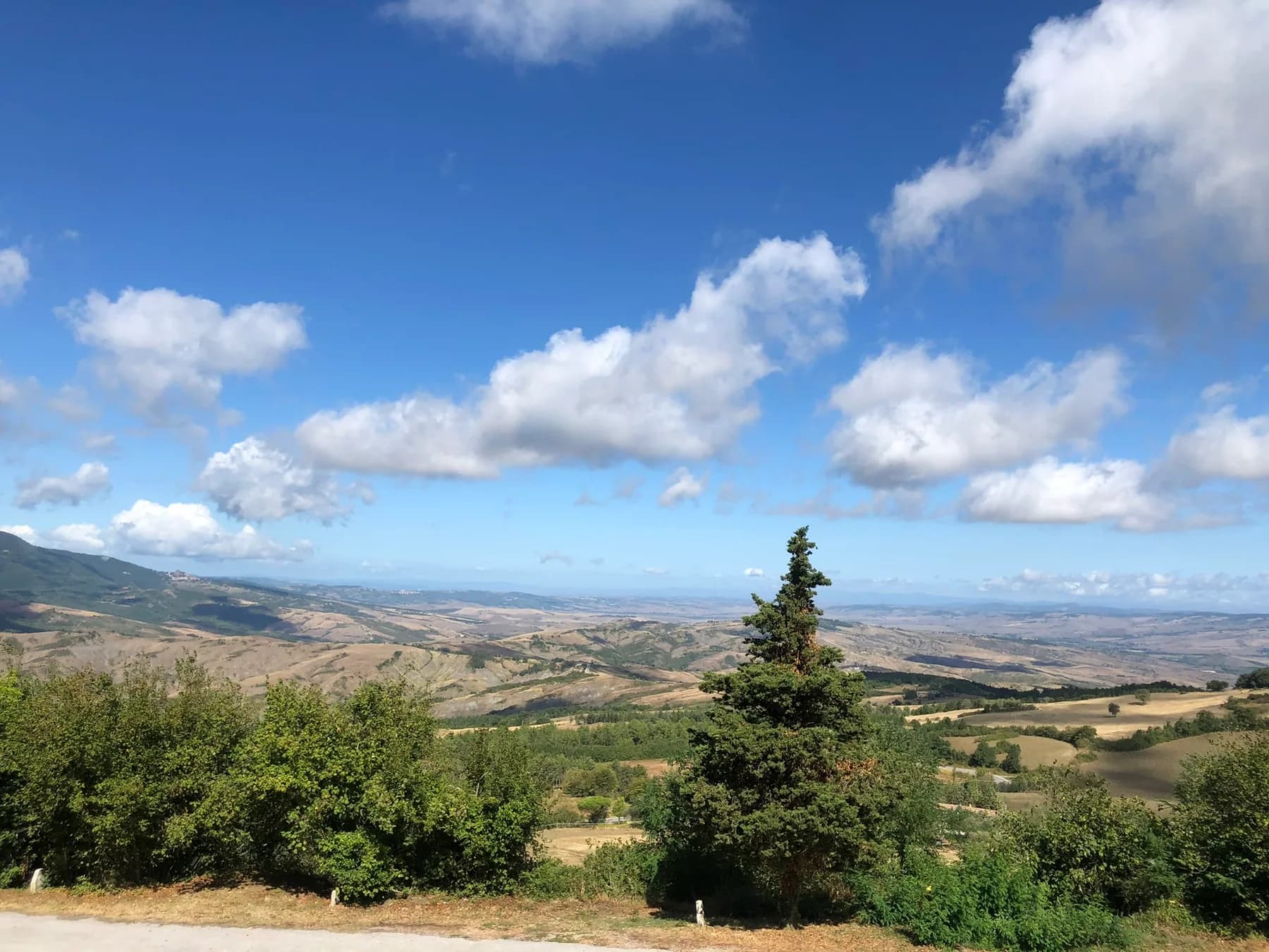 Toscaanse heuvels met cipressen onder een blauwe lucht