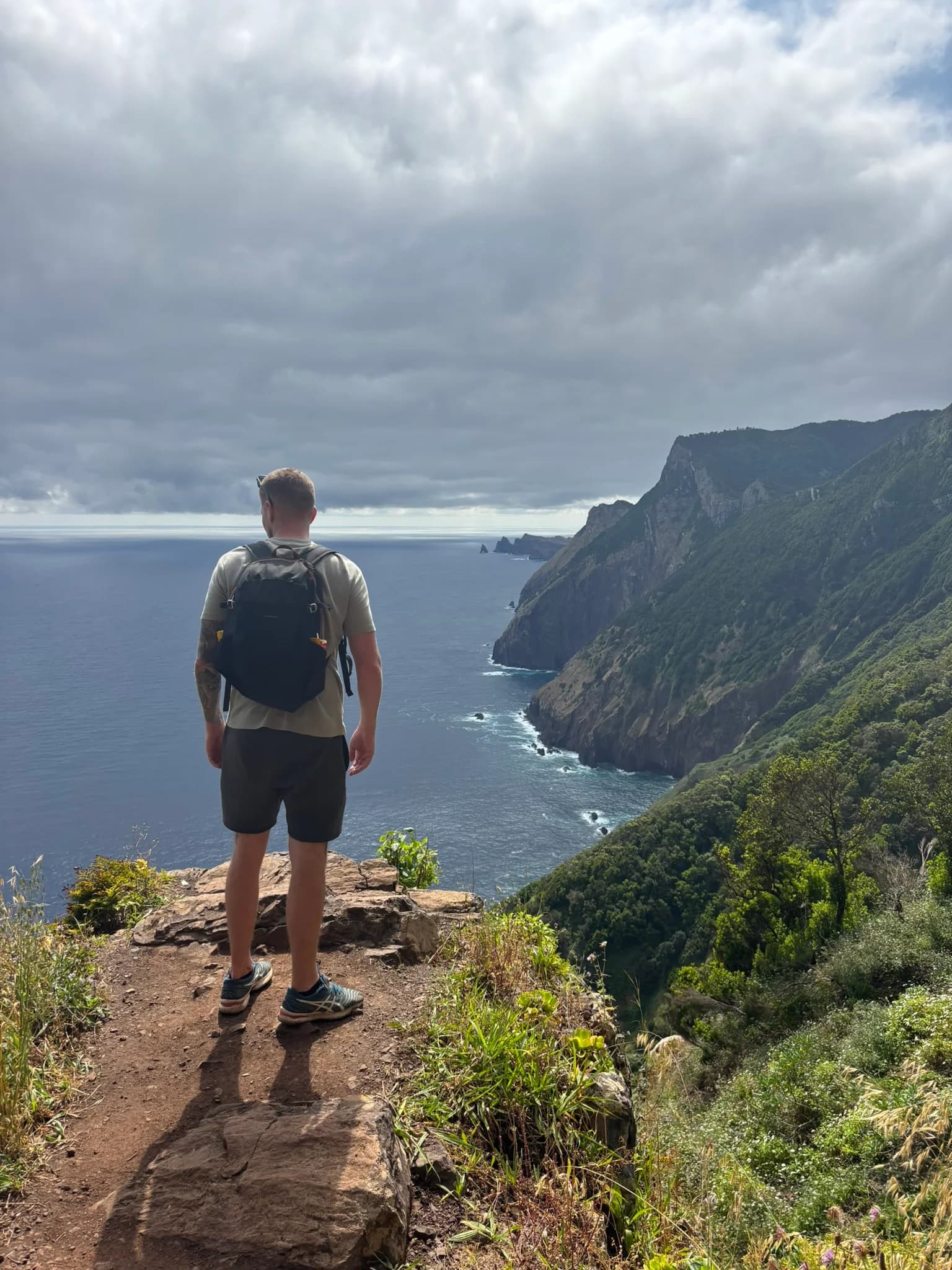 Wandelaar kijkt vanaf Boca do Risco uit over de kliffen en de Atlantische Oceaan