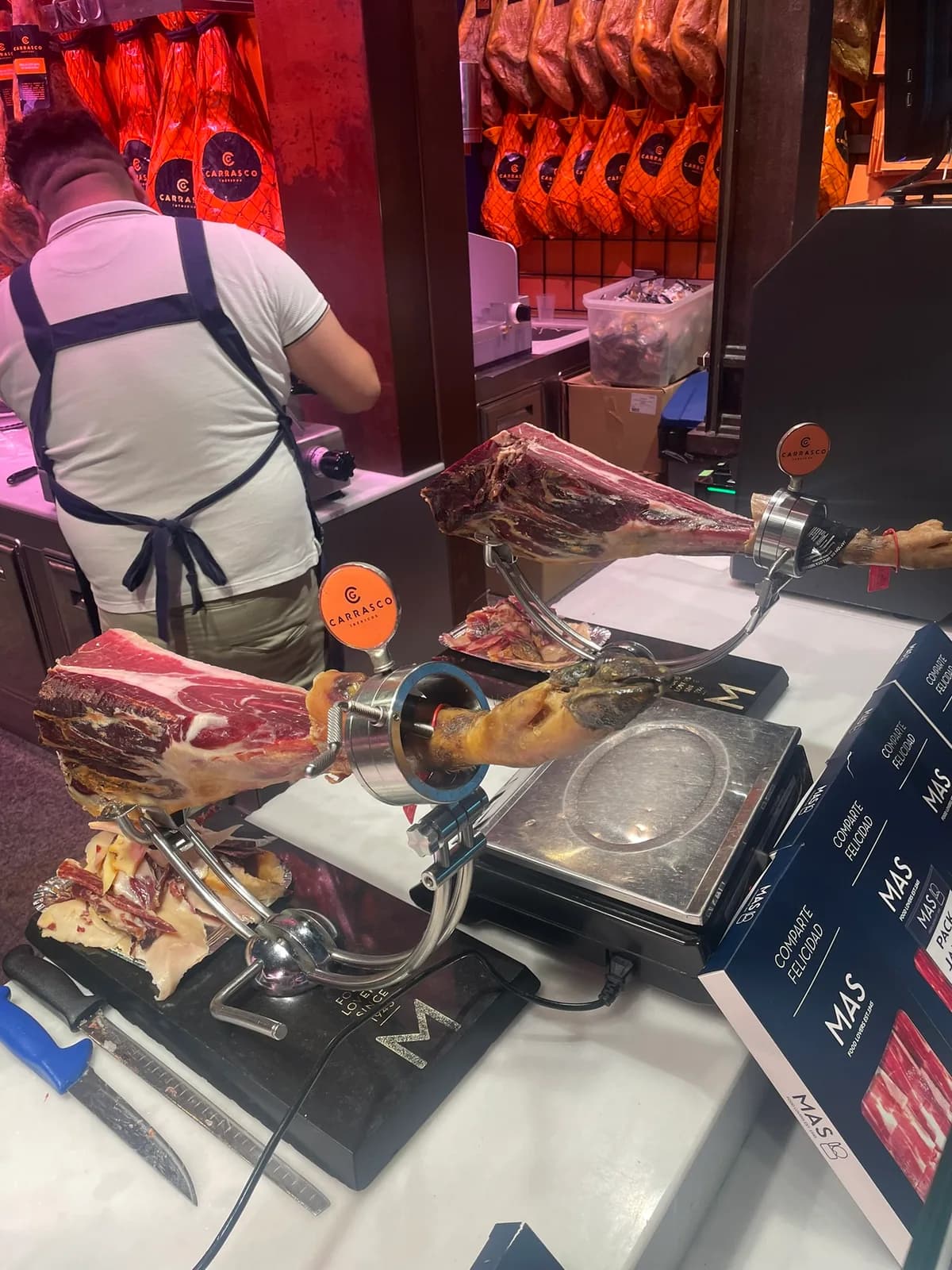 Jamón wordt aangesneden bij een kraam in Mercado de San Miguel