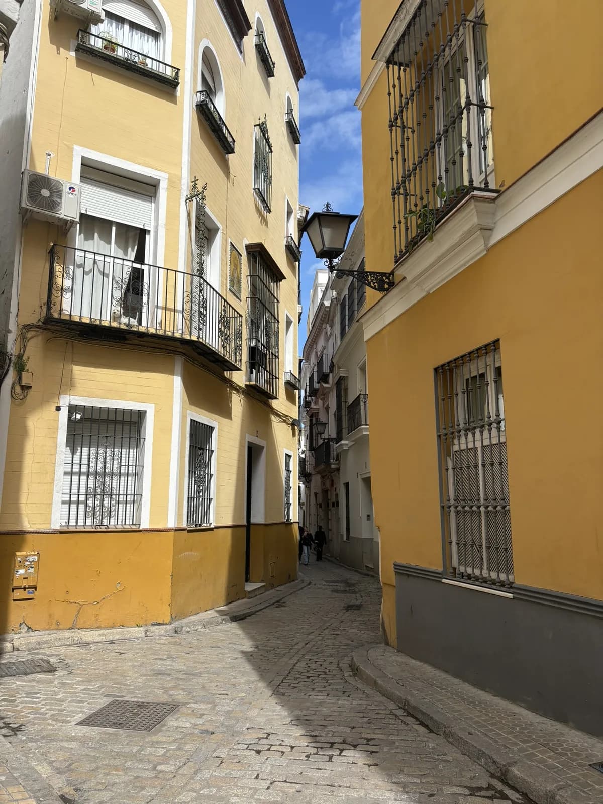 Smalle straat met gele gevels in het historische centrum van Sevilla