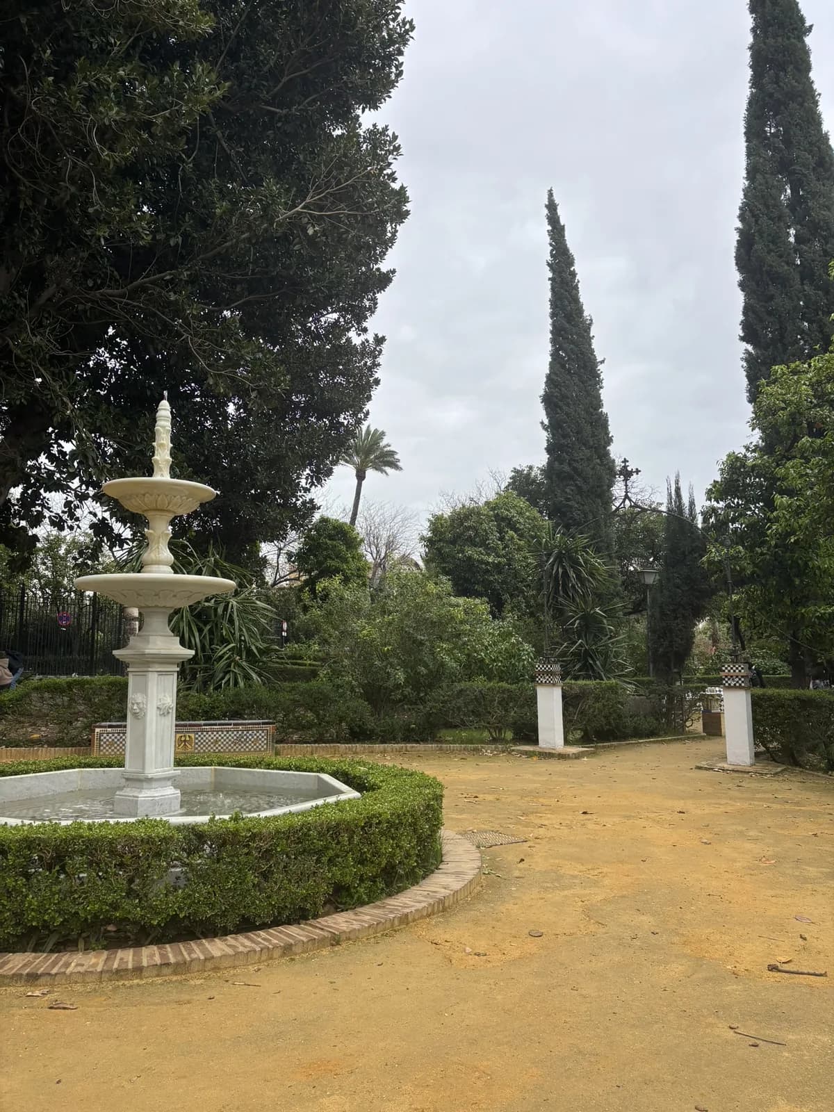 Groene tuin in Sevilla met een fontein en tegelbanken