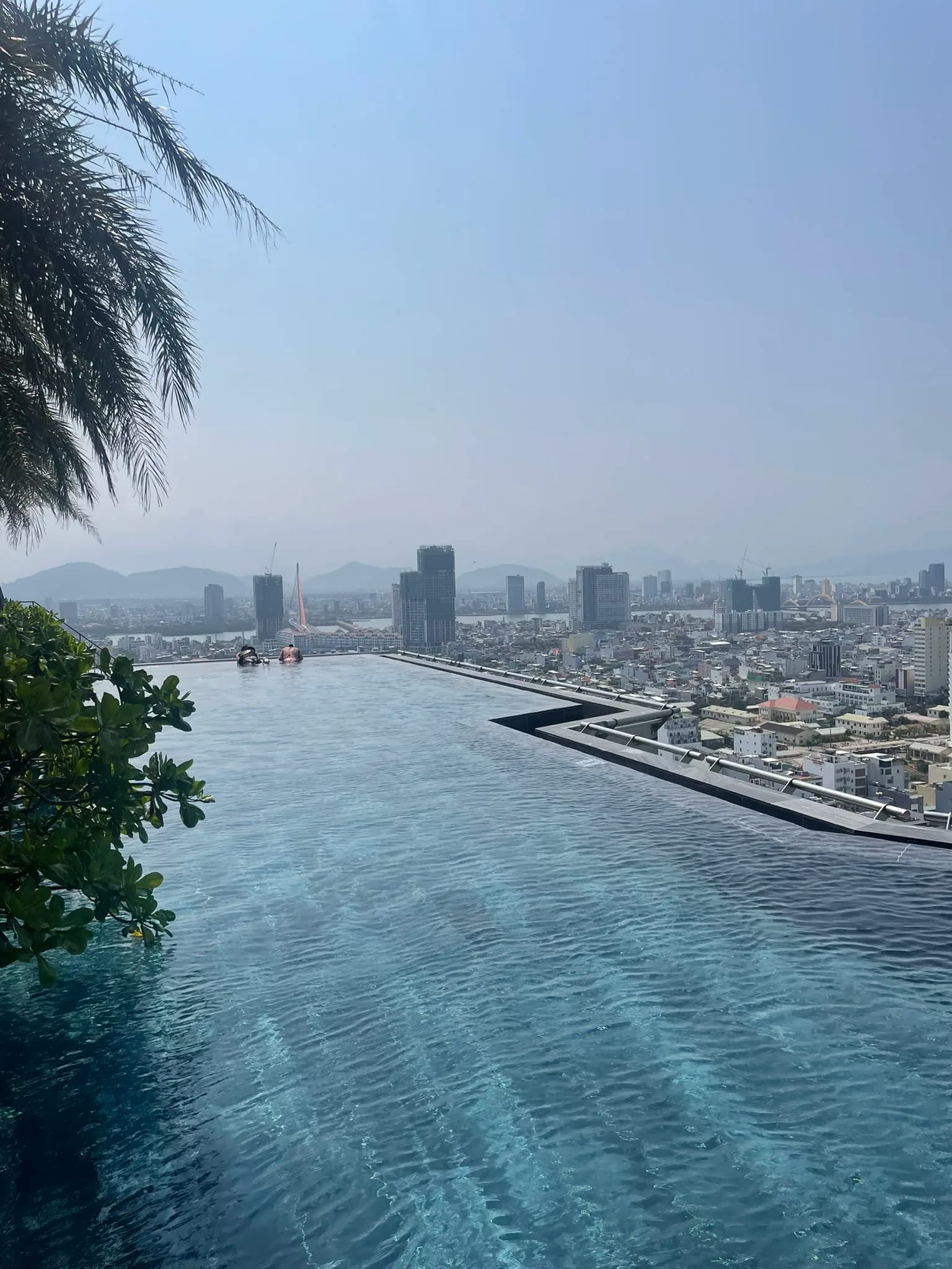 Zwembad hoog boven de kust en stad van Da Nang