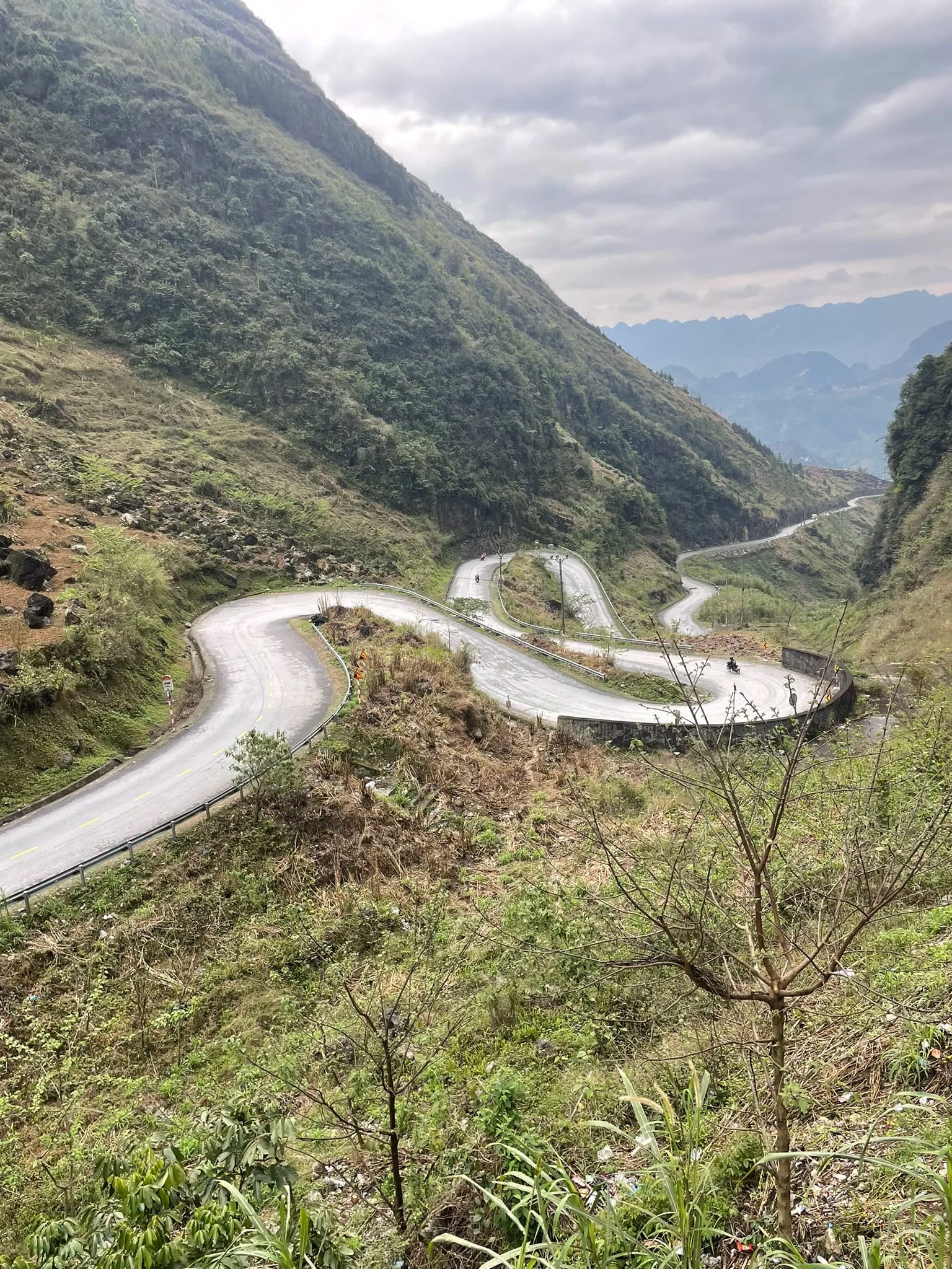 Haarspeldbochten door een groene bergvallei in Ha Giang