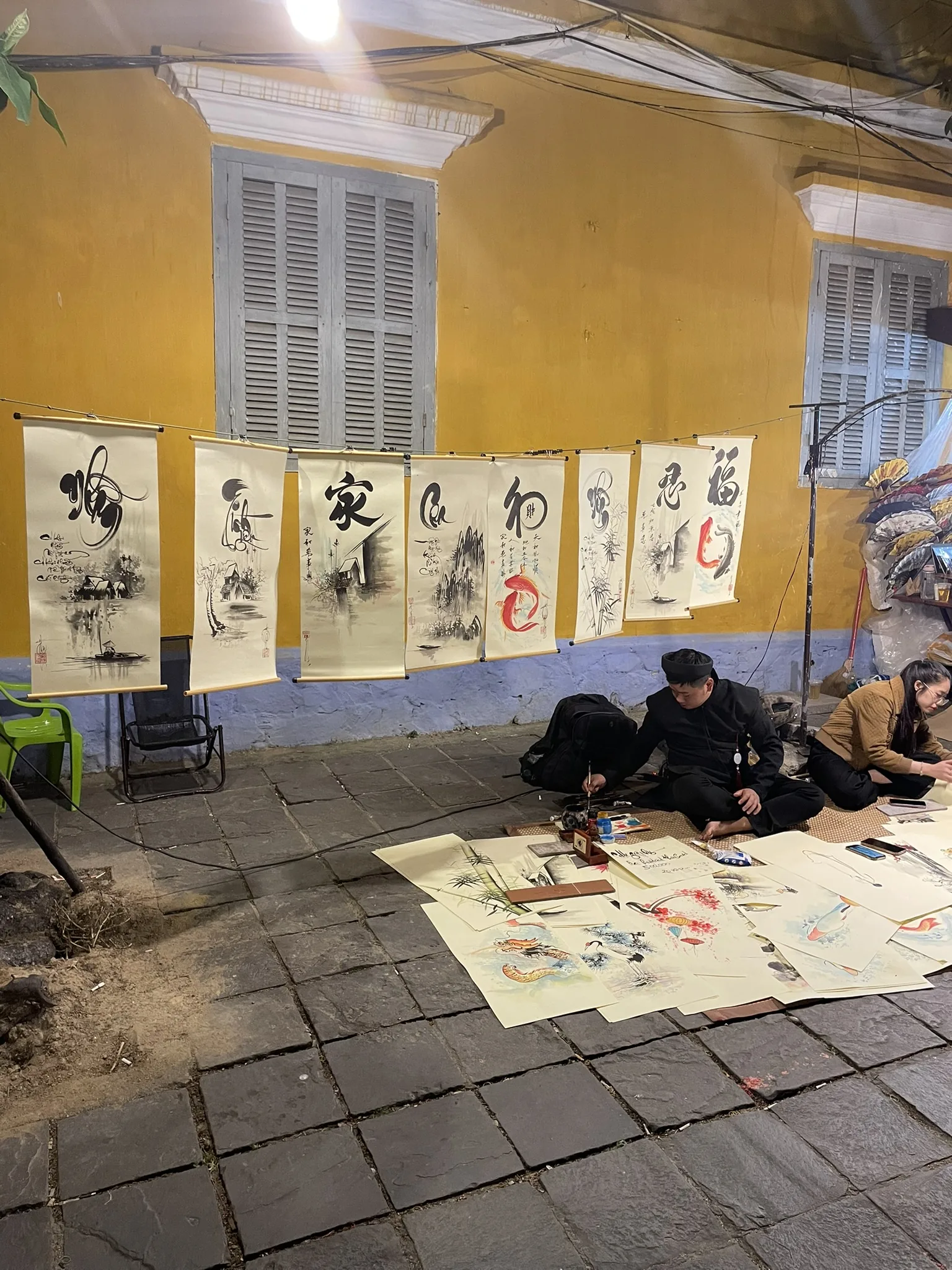 Kunstwerken en kalligrafie uitgestald in een straat van Hoi An